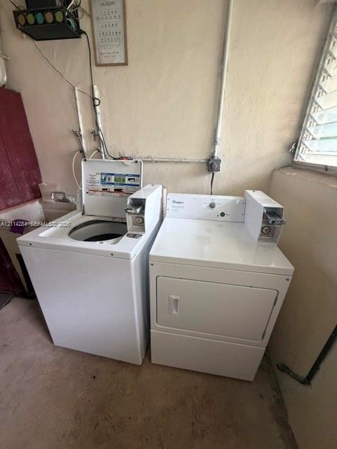 Laundry area featuring white coin-operated washer and dryer units, a utility sink, and a louvered window