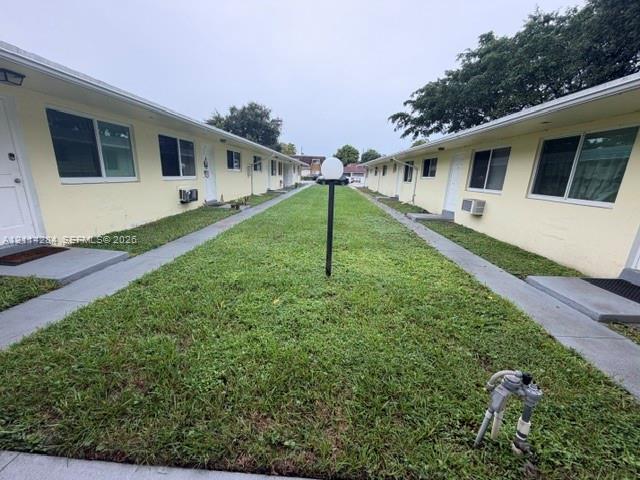 Exterior courtyard featuring dual concrete walkways, manicured lawn, and post-mounted globe lighting