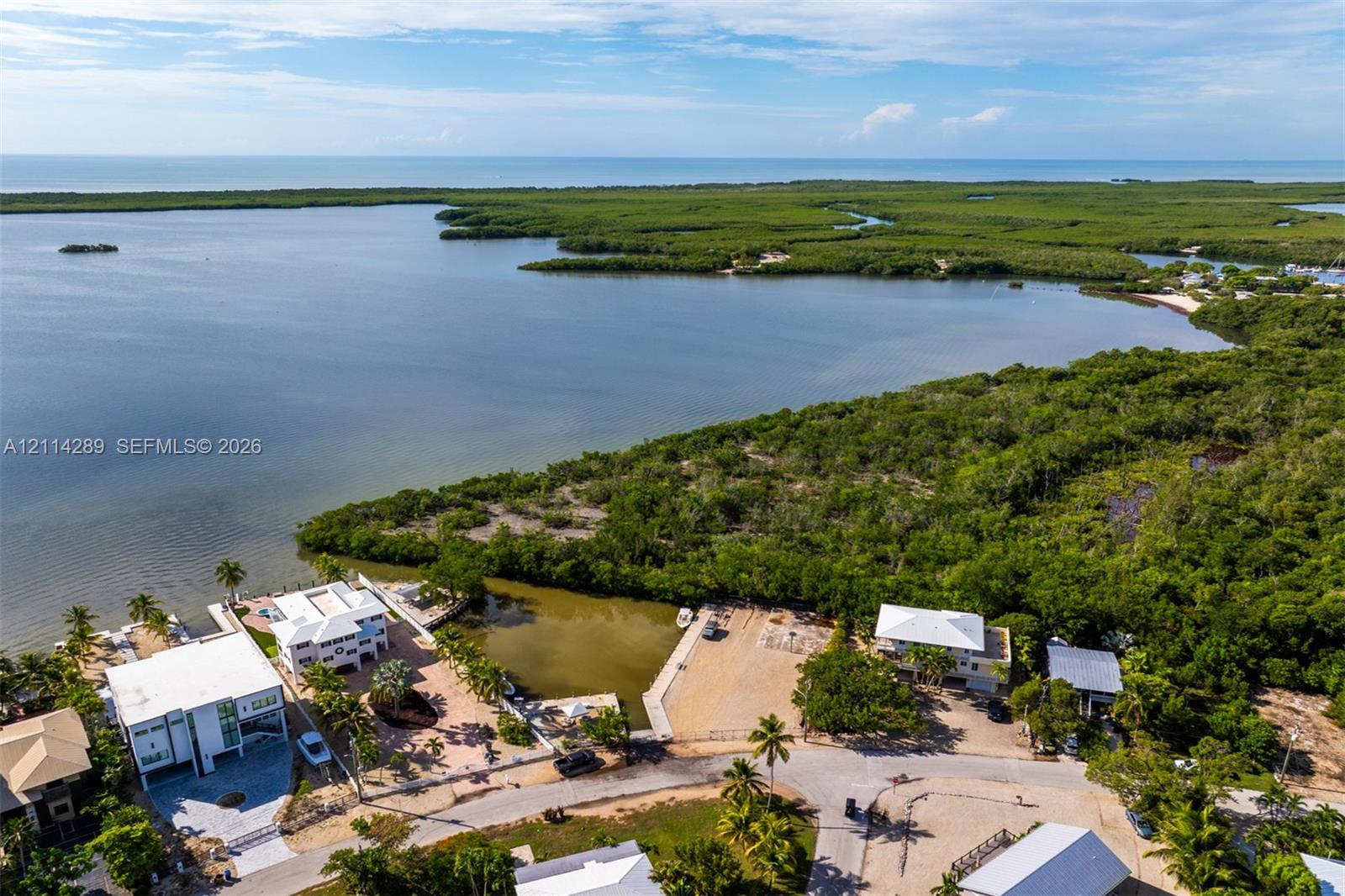 Waterfront property featuring a private boat slip, dock infrastructure, and direct access to coastal waterways, surrounded by native vegetation
