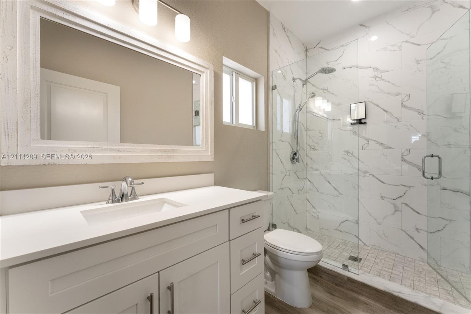 Bathroom featuring a vanity with white cabinetry, a rectangular sink, and a solid-surface countertop