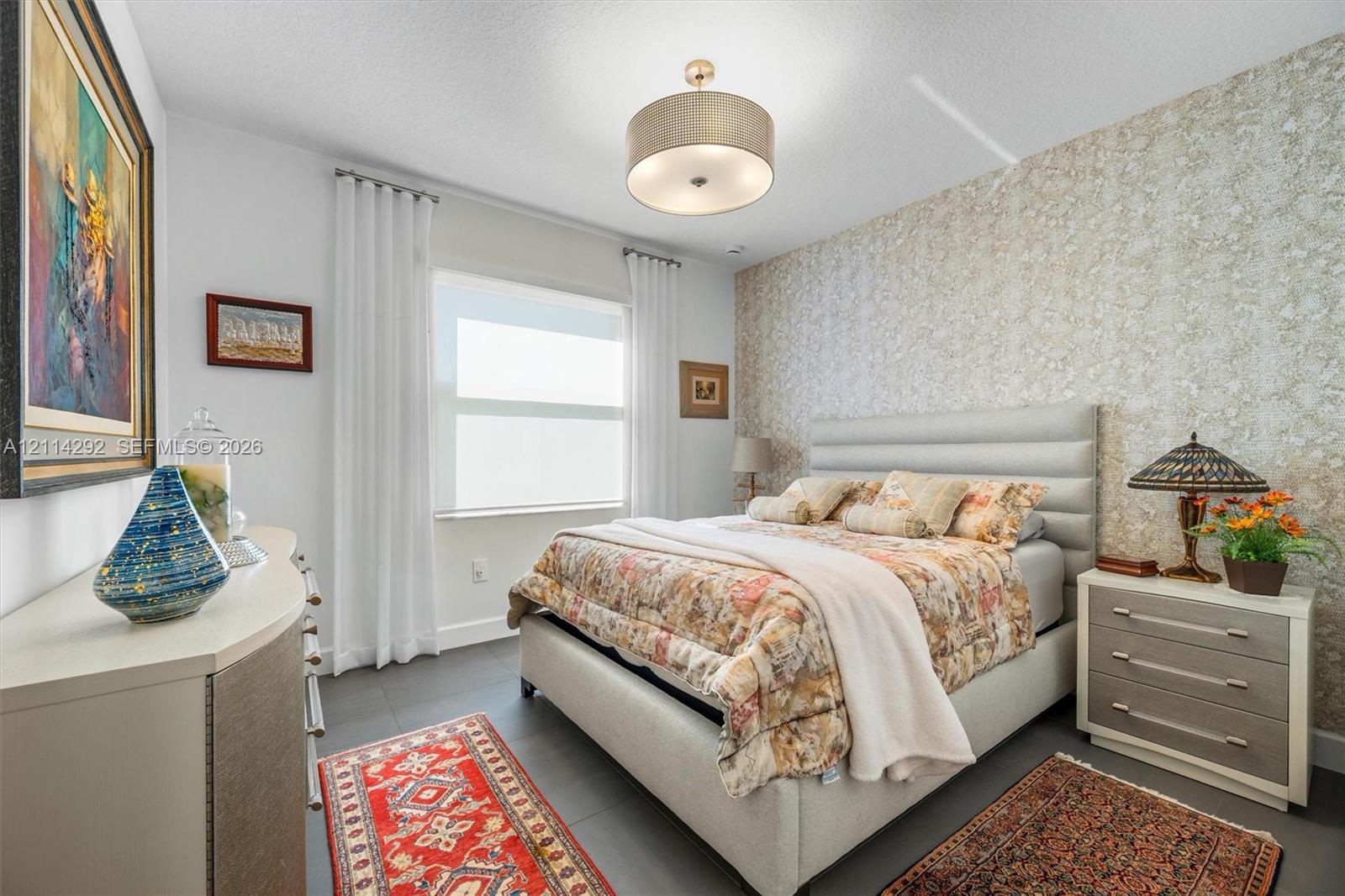 Textured wallpaper accent wall, large-format tile flooring, and drum-style ceiling light fixture