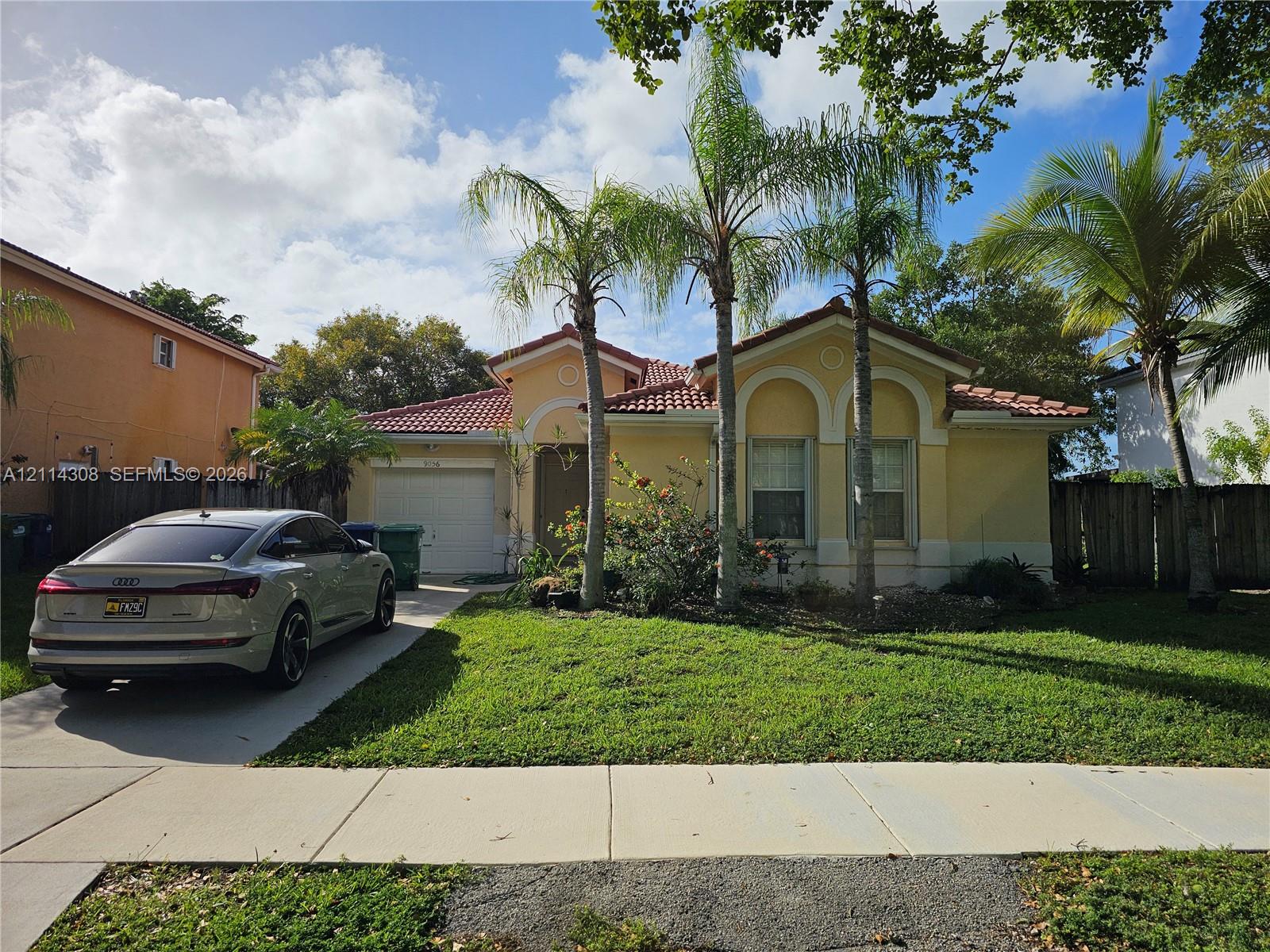 Single-story residence featuring a tile roof, stucco exterior, arched window detailing, and an attached garage