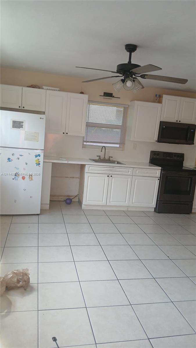 Kitchen featuring white shaker-style cabinetry, tile flooring, a dual-basin sink, and a ceiling fan