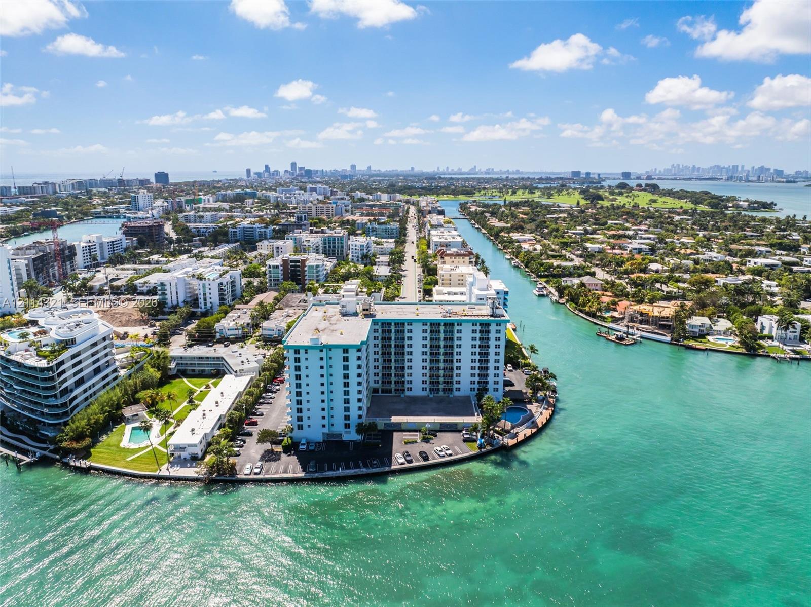 High-rise coastal building featuring waterfront positioning, expansive marine exposure, surface parking, and a dedicated pool area
