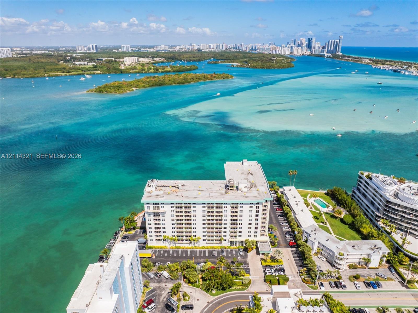Aerial perspective of a waterfront residential complex featuring expansive coastal surroundings, direct water frontage, and proximity to the open bay