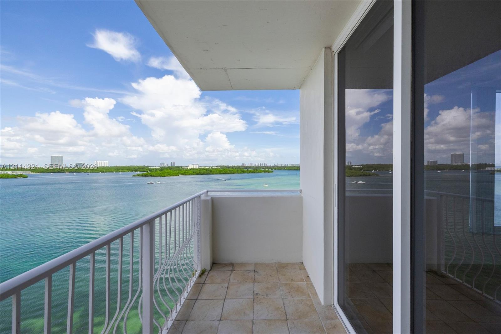 Private covered balcony featuring ceramic tile flooring, a white metal railing, and direct water exposure