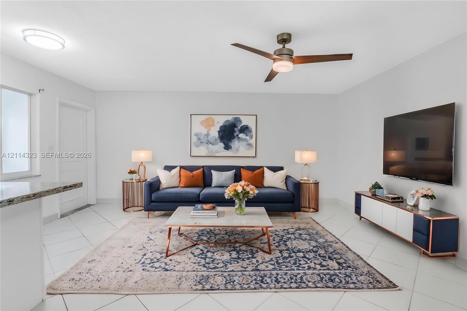 VIRTUALLY STAGED Living area featuring large-format diagonal tile flooring, a modern ceiling fan with integrated lighting, and a flush-mount circular overhead light fixture