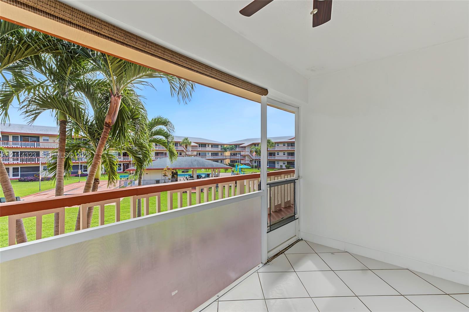 Screened-in balcony featuring tile flooring, a ceiling fan, and metal railings