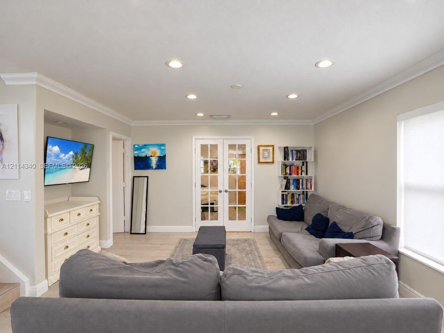 Interior space featuring recessed lighting, crown molding, light-toned tile flooring, and glass-paned double doors