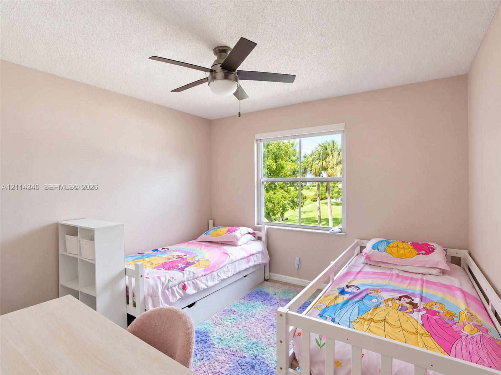 Bedroom featuring a brushed nickel ceiling fan with integrated lighting, a single-hung window, and neutral wall paint