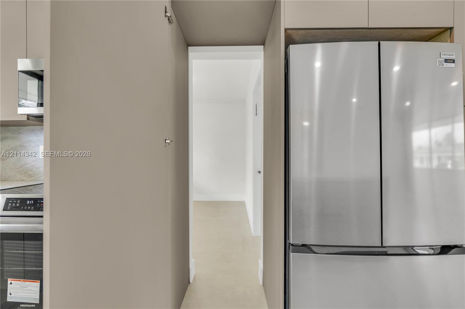 Kitchen featuring stainless steel refrigerator, integrated cabinetry, and built-in microwave