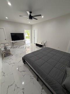 Large-format tile flooring with marble-style veining, recessed lighting, and a modern ceiling fan