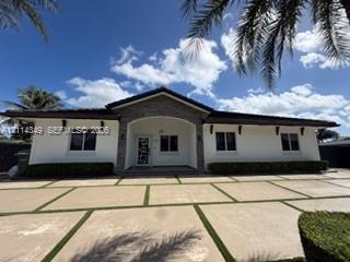 Single-story residence featuring a stone-accented entryway, a concrete paver driveway with turf detailing, and exterior decorative corbels Single-story residence featuring a stone-accented entryway, a concrete paver driveway with turf detailing, and exterior decorative corbels