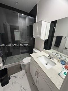 Bathroom featuring a glass-enclosed shower with tile surround, white cabinetry, integrated sink with stone-finish countertop, and large-format porcelain tile flooring