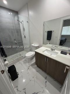 Bathroom featuring a large-format tiled floor, a vanity with a light-toned countertop, and a walk-in shower enclosed by a frameless glass door with floor-to-ceiling stone-finish tiling