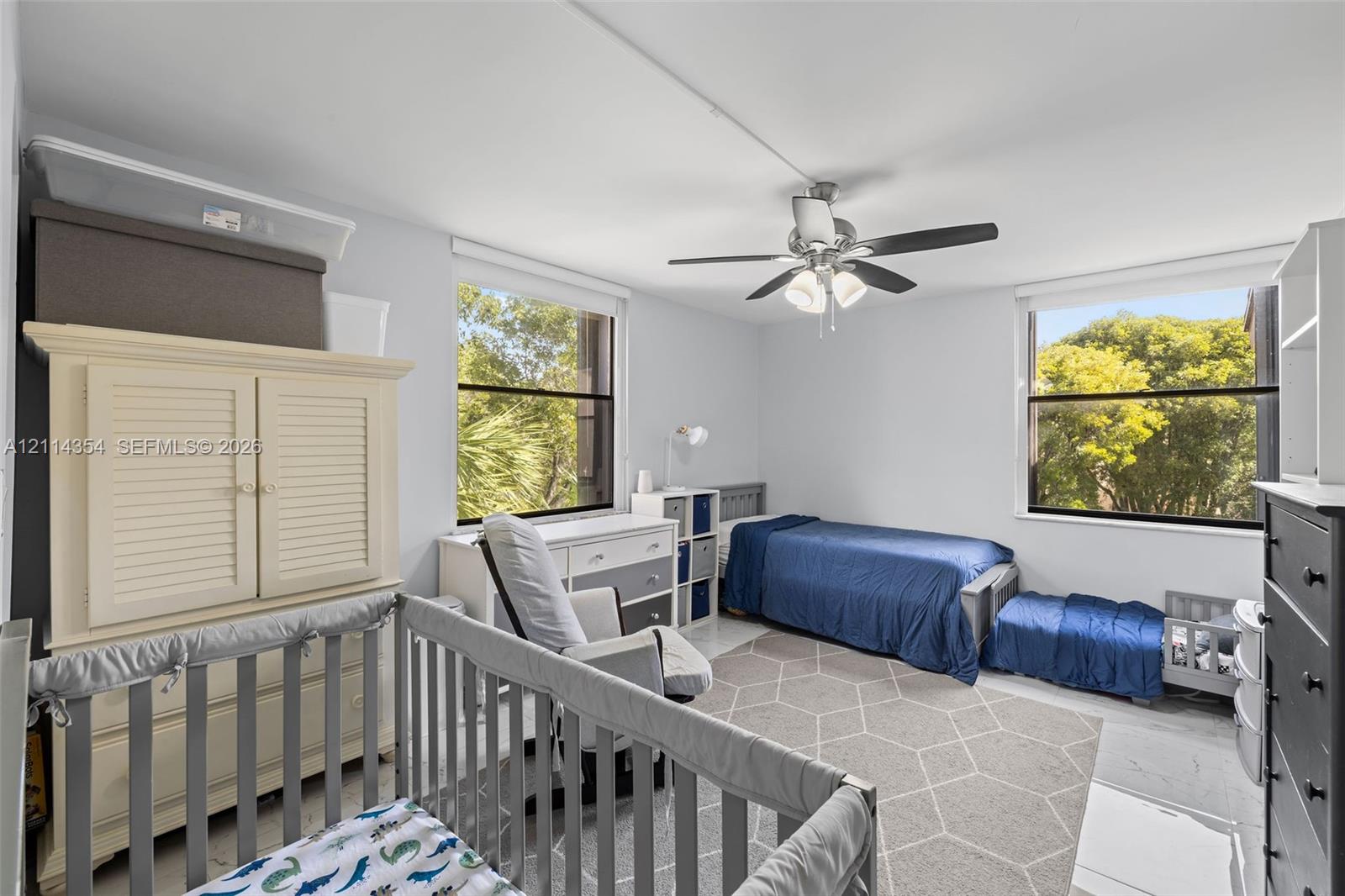 Room with dual-pane windows, neutral wall coloring, and a central ceiling fan with integrated lighting