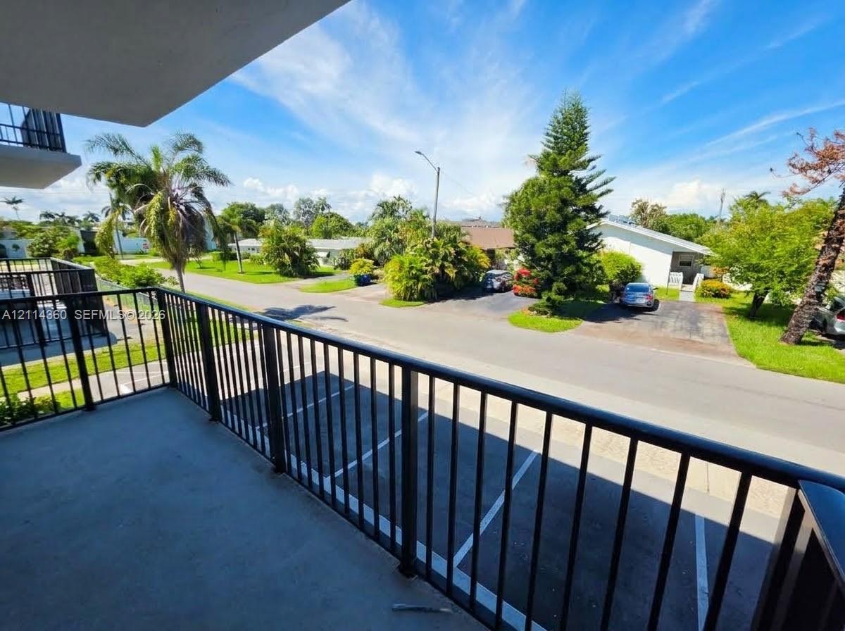 Covered balcony featuring black metal railings and concrete flooring Covered balcony featuring black metal railings and concrete flooring
