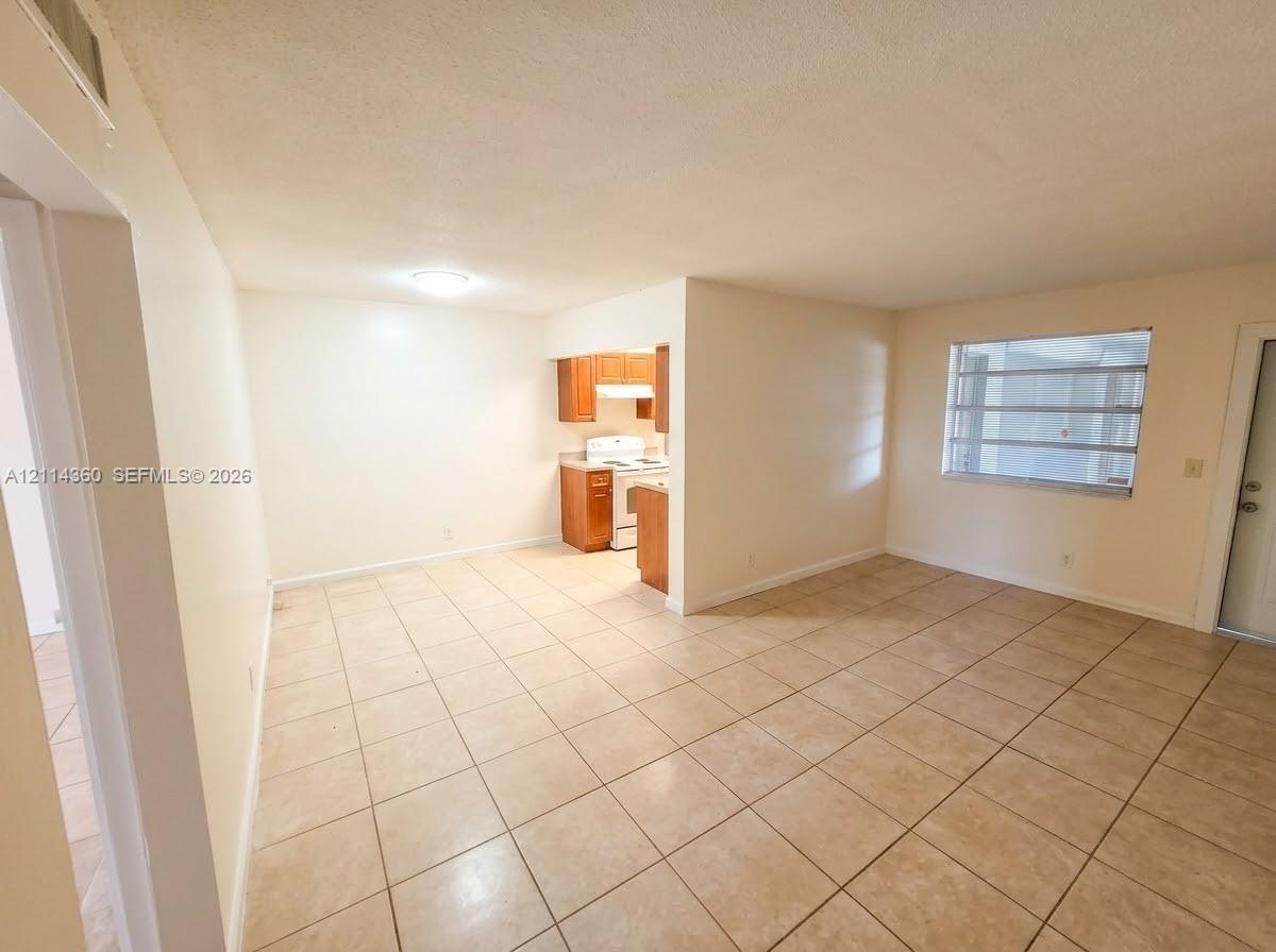 Neutral-toned ceramic tile flooring, built-in wooden cabinetry, recessed lighting, and multi-pane horizontal window Neutral-toned ceramic tile flooring, built-in wooden cabinetry, recessed lighting, and multi-pane horizontal window