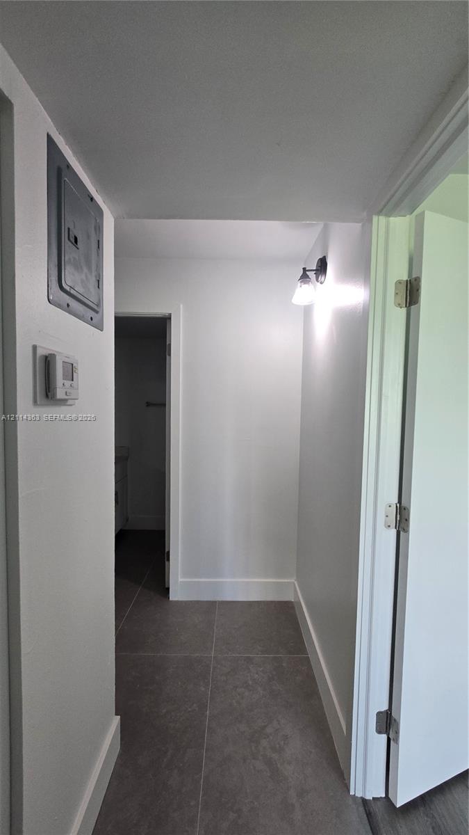 Neutral-toned large-format tile flooring and wall-mounted sconce lighting