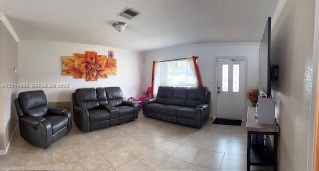 Living space featuring large-format ceramic tile flooring, crown molding, and an exterior door with dual glass panels
