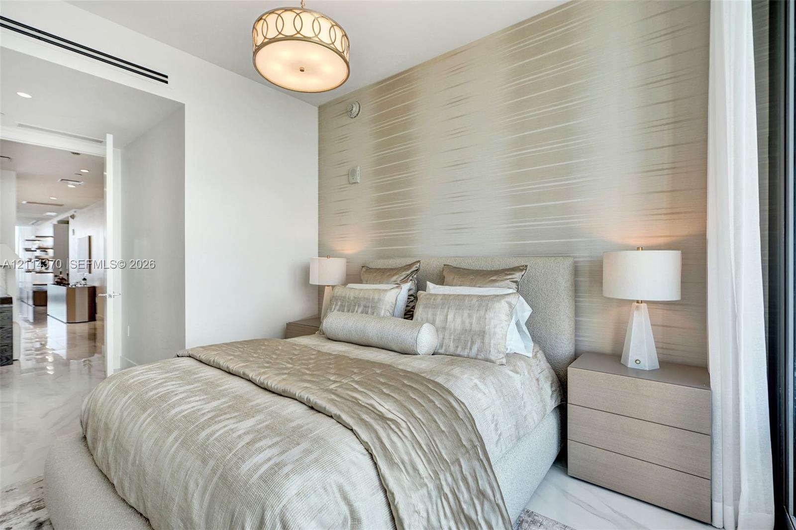 Textured wall treatment, polished stone flooring, and custom circular pendant lighting