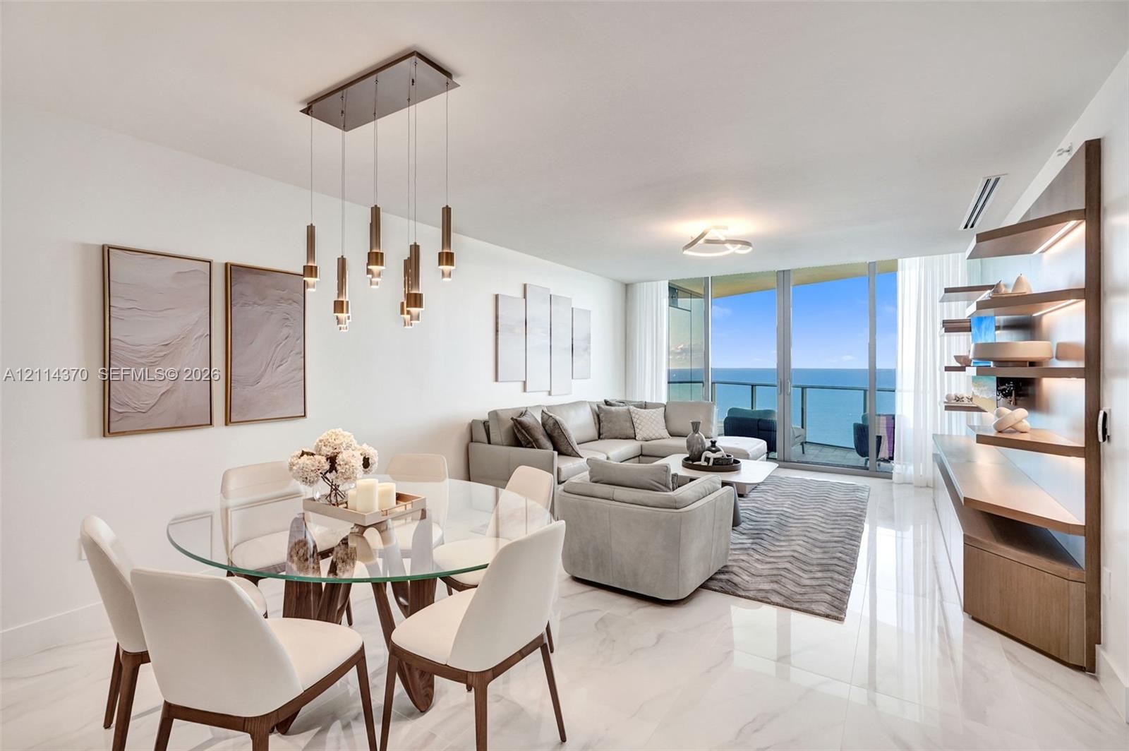 Polished stone flooring throughout, floor-to-ceiling glass panel doors, custom built-in wooden shelving with integrated lighting, and a multi-pendant rectangular light fixture