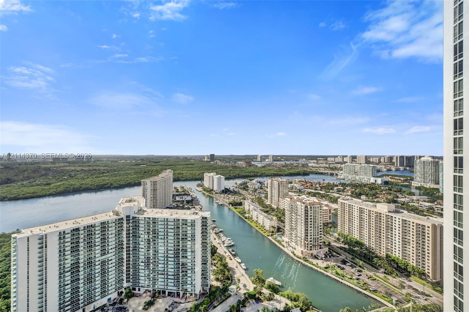 High-rise perspective featuring expansive water frontage, coastal surroundings, and panoramic skyline vistas