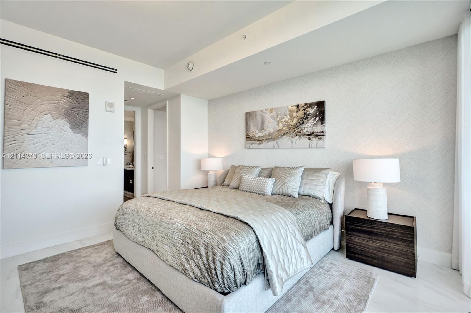 High ceilings with recessed lighting, light-toned stone-finish flooring, and textured accent wall covering