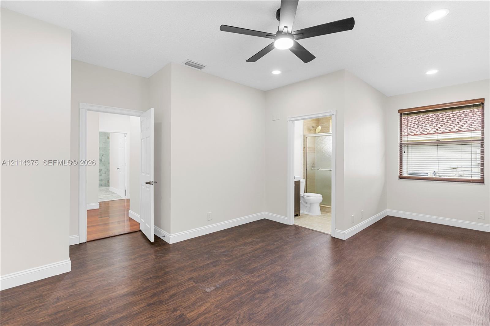 Interior space featuring wood-finish flooring, a multi-blade ceiling fan with integrated lighting, recessed lighting, and a window with horizontal blinds
