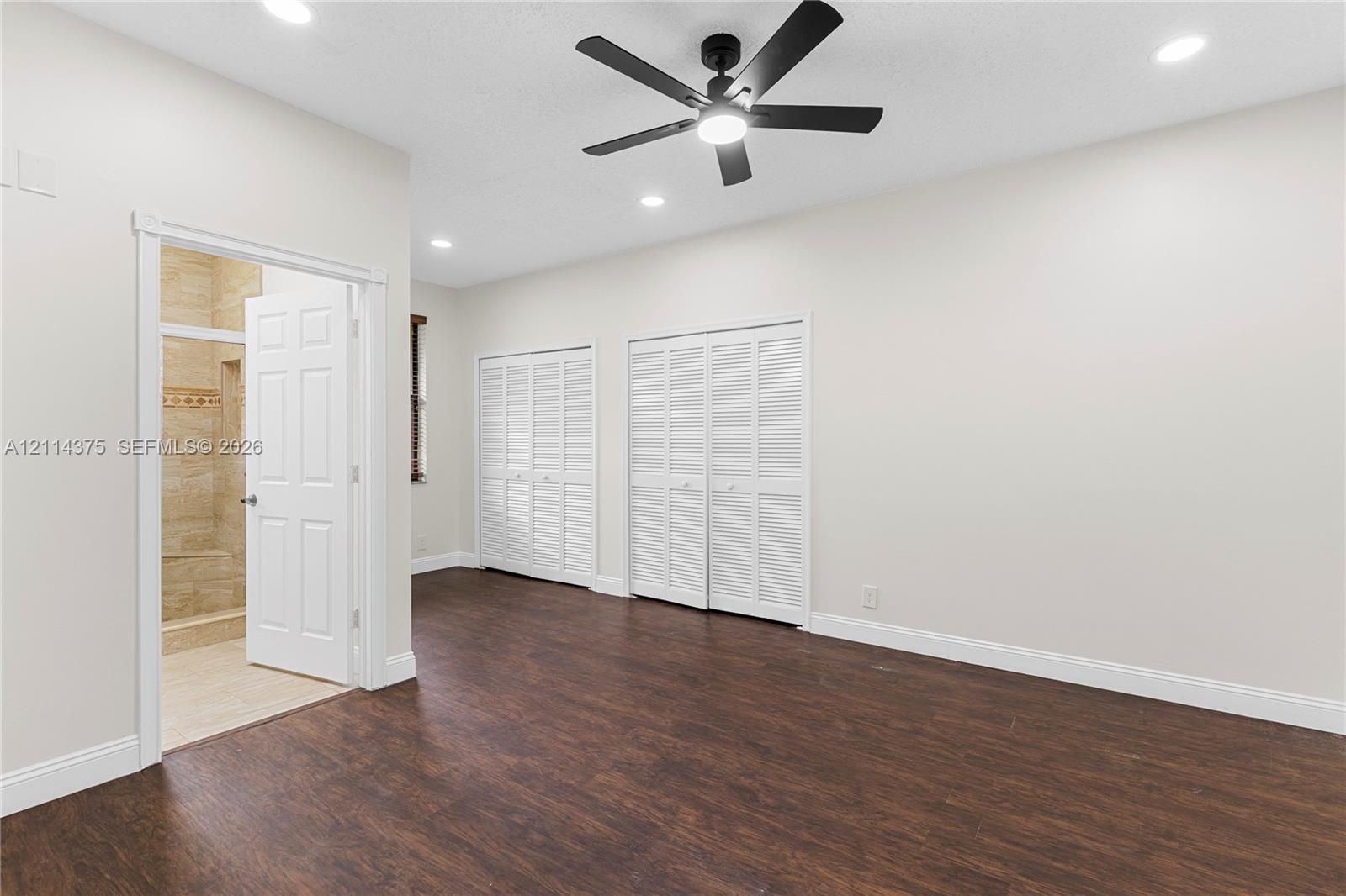 Wood-finish flooring, recessed lighting, ceiling fan with integrated light, and two sets of louvered-style closet doors