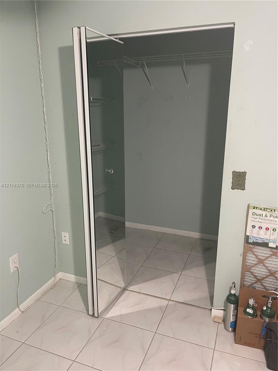 Storage space featuring mirrored bypass closet doors and wire shelving
