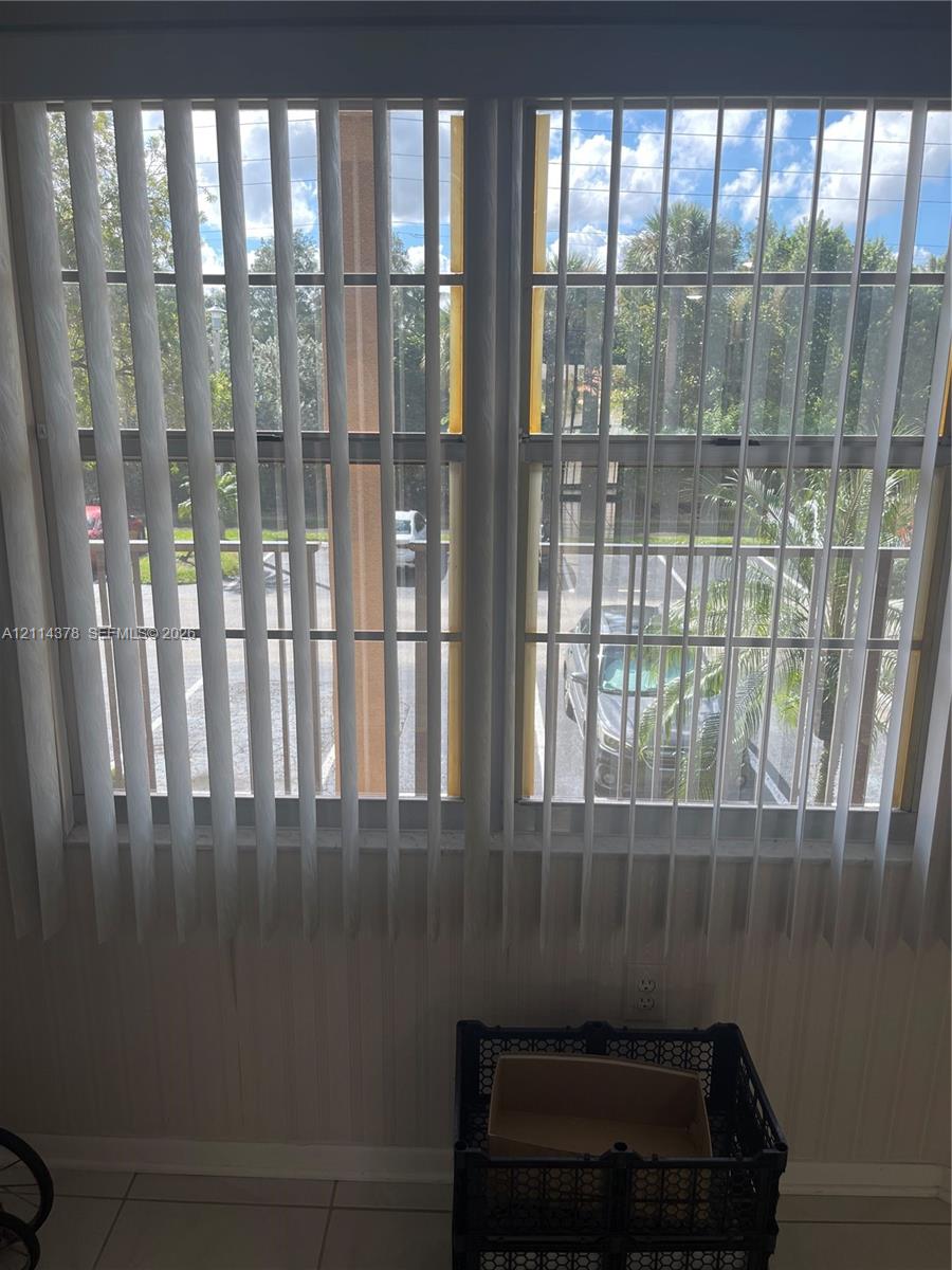 Dual-pane windows featuring vertical blinds and light-tone tile flooring