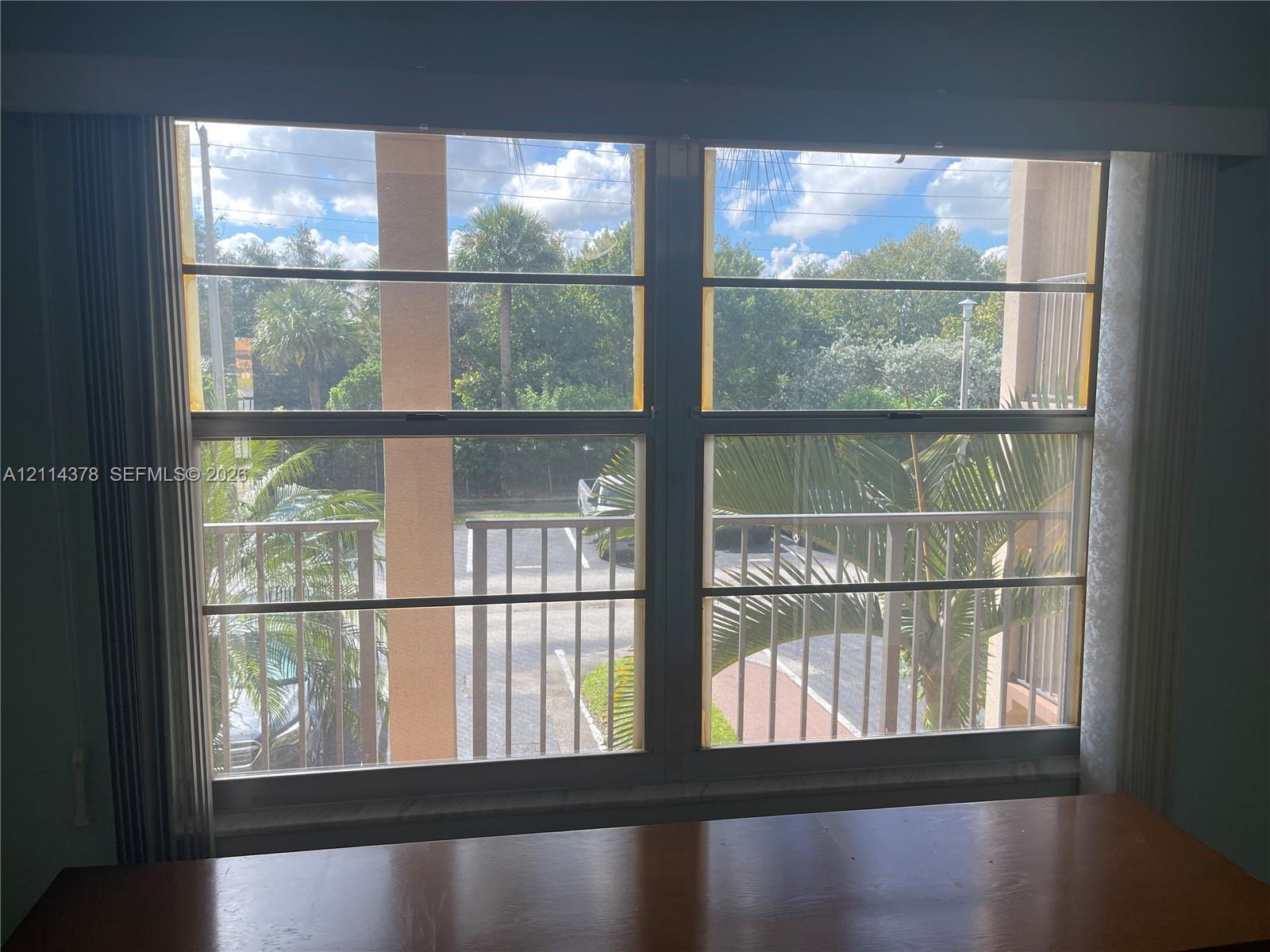 Large dual-pane window featuring a horizontal slider mechanism and metal balcony railing