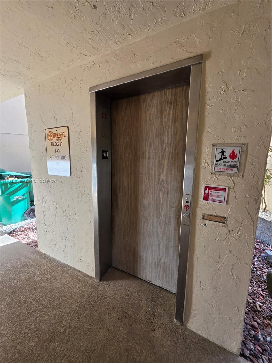 Elevator access featuring a wood-finish door and brushed metal frame