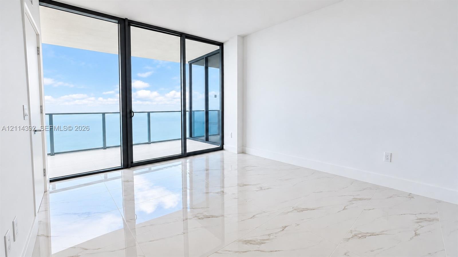 Floor-to-ceiling sliding glass doors, oversized tile flooring, and a glass-paneled balcony Floor-to-ceiling sliding glass doors, oversized tile flooring, and a glass-paneled balcony