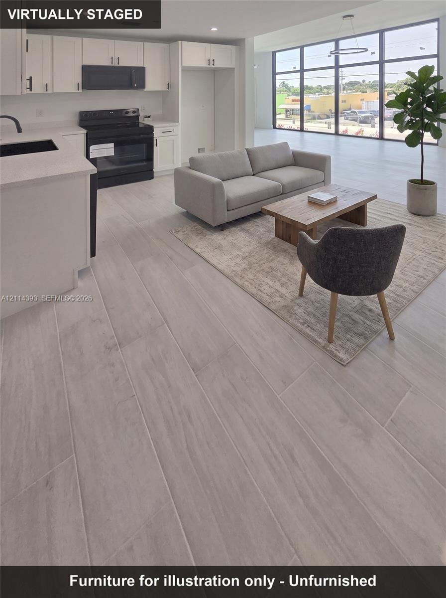 Kitchen featuring white cabinetry, solid-surface countertops, and black built-in appliances, complemented by wood-finish tile flooring and floor-to-ceiling windows