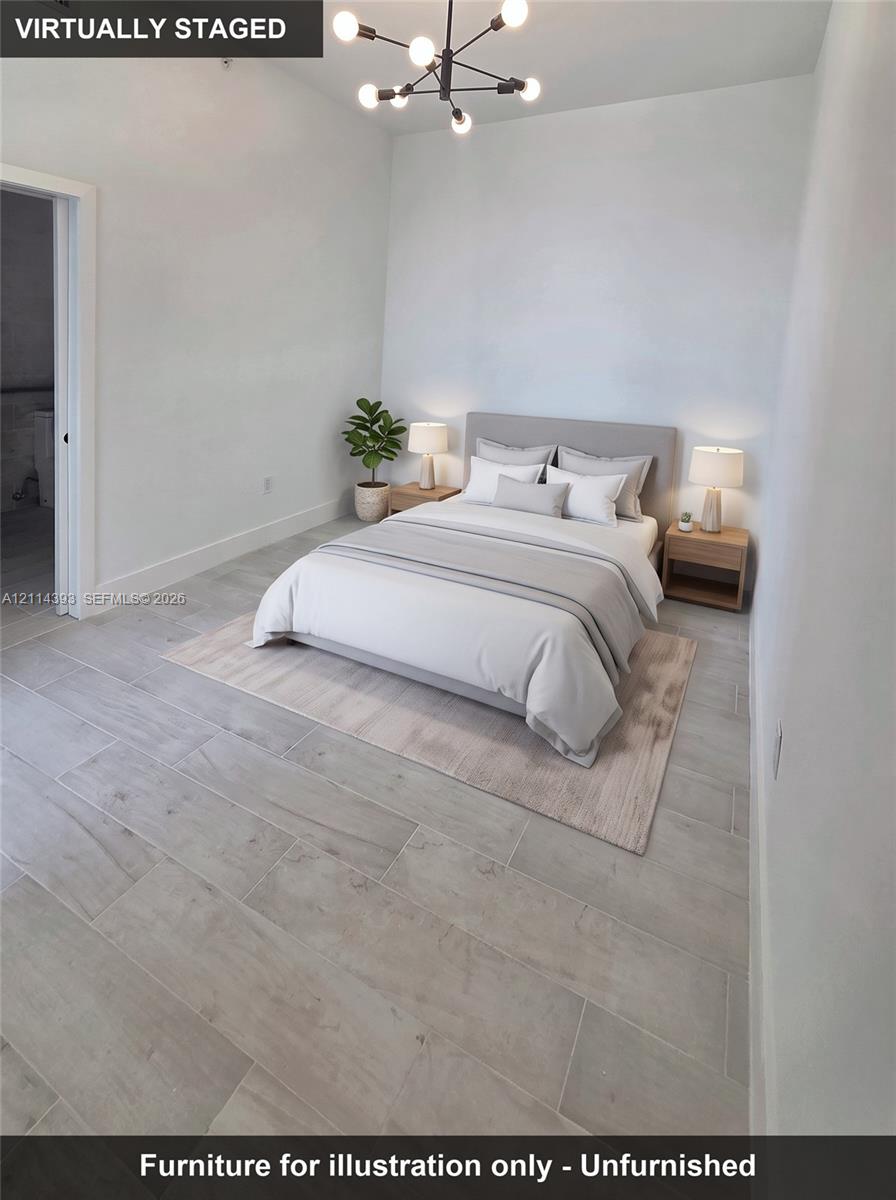 High-ceiling room featuring neutral paint, wood-finish flooring, and a modern multi-arm light fixture