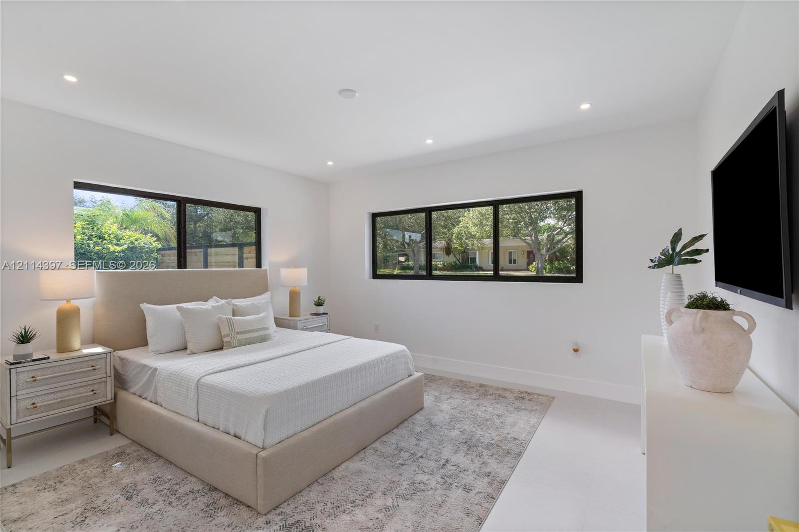 Bedroom featuring large windows with black frames, recessed ceiling lighting, and smooth-finish flooring