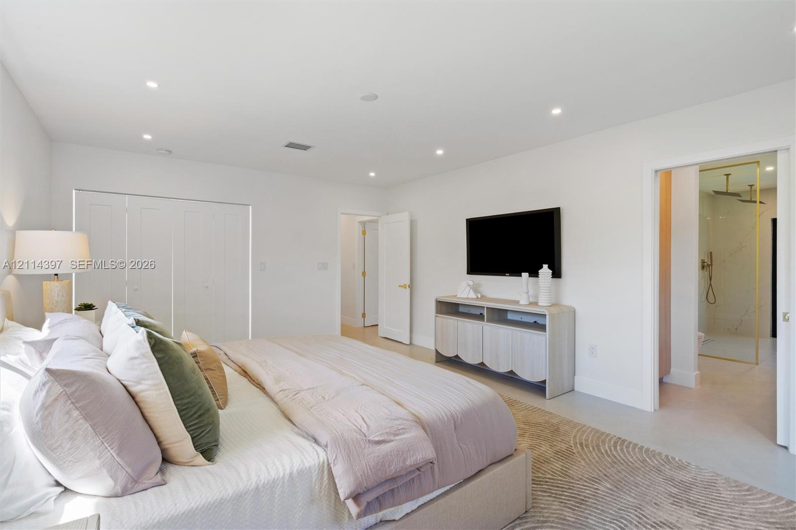 Neutral-toned interior featuring recessed ceiling lighting, a large-format tile floor, and bi-fold closet doors