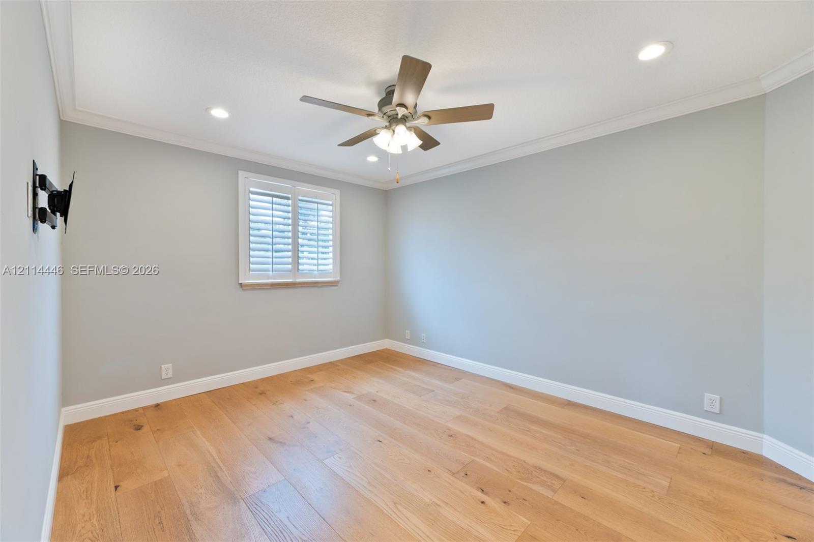 Wood-finish flooring, ceiling fan with integrated lighting, recessed lighting, crown molding, and plantation shutters