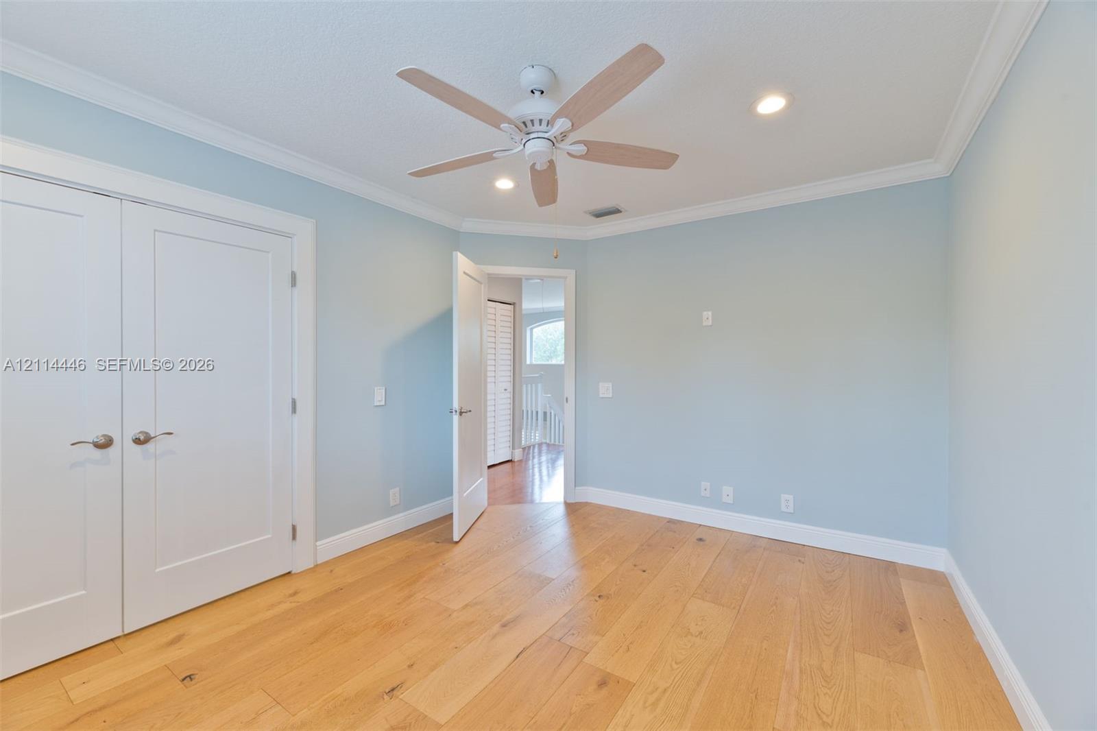 Room featuring wood-finish flooring, recessed lighting, and a multi-blade ceiling fan