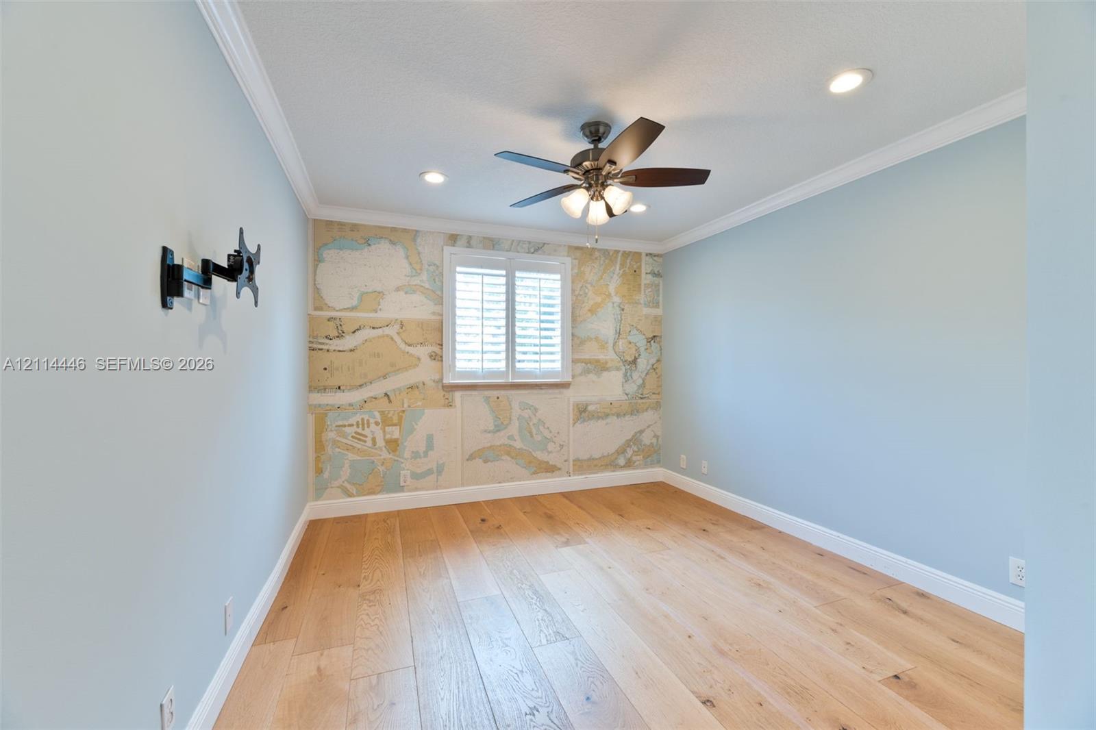 Interior space featuring wood-finish flooring, crown molding, recessed lighting, a ceiling fan, and plantation shutters