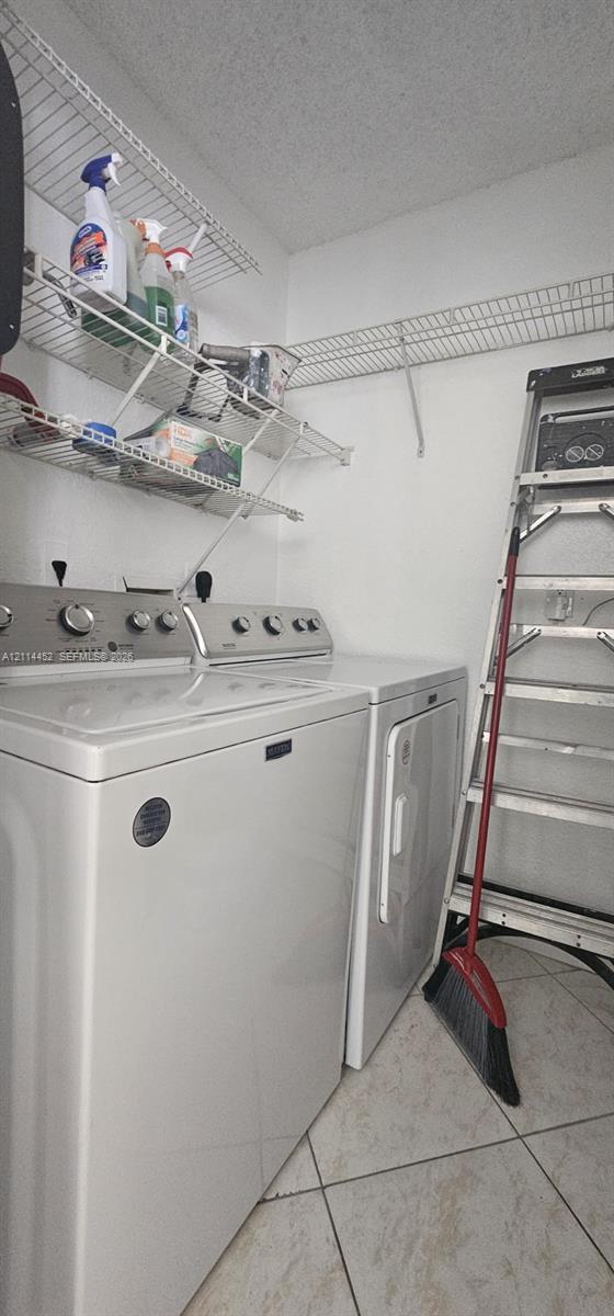 Laundry area featuring light-toned ceramic tile flooring and multi-tier wire shelving Laundry area featuring light-toned ceramic tile flooring and multi-tier wire shelving