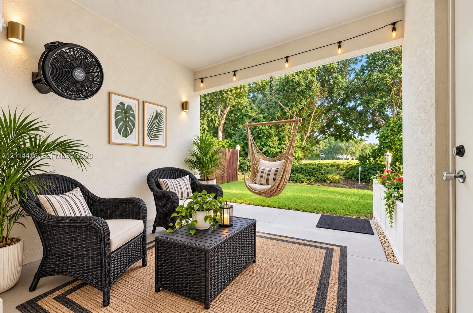 Covered patio featuring concrete flooring, wall-mounted fan, and exterior wall-mounted lighting