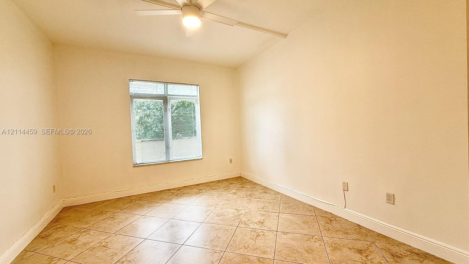 Interior room featuring diagonal-set tile flooring, a ceiling fan with integrated lighting, and a multi-pane window