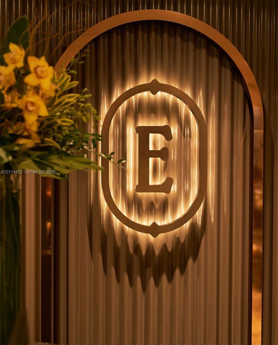 Arched entryway featuring ribbed wall paneling and a custom backlit metal insignia