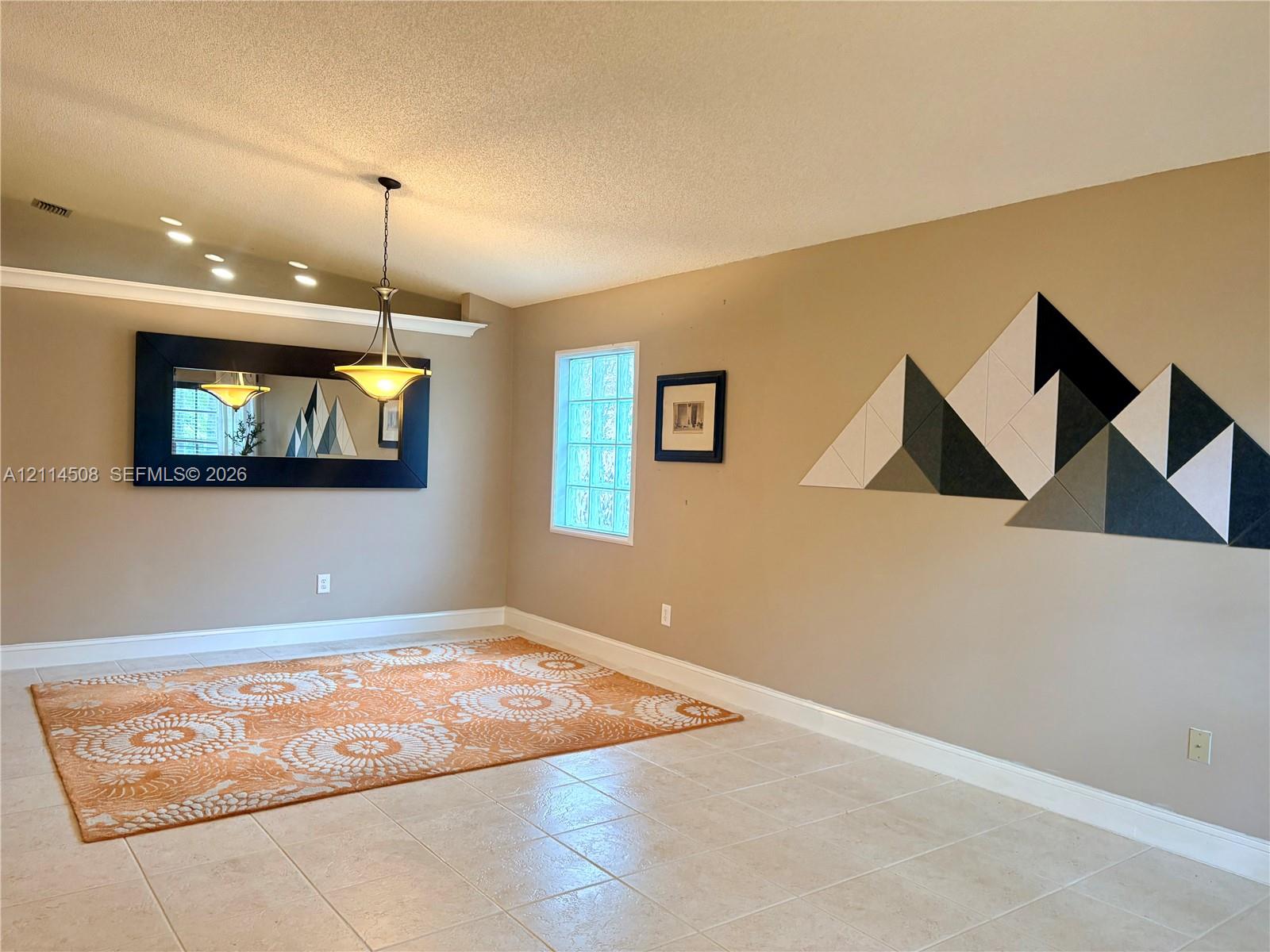 Ceramic tile flooring, crown molding, a hanging pendant light fixture, and a glass block window Ceramic tile flooring, crown molding, a hanging pendant light fixture, and a glass block window