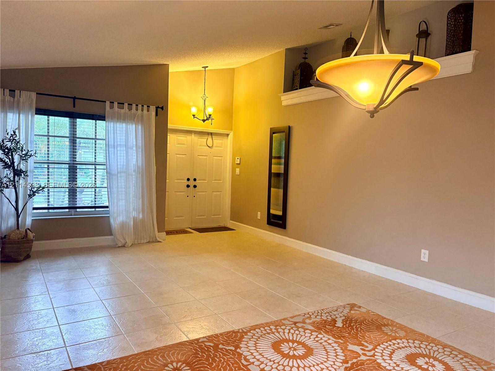 Vaulted ceilings, tiled flooring, double-entry front doors, built-in display niche, and multi-light pendant fixtures Vaulted ceilings, tiled flooring, double-entry front doors, built-in display niche, and multi-light pendant fixtures