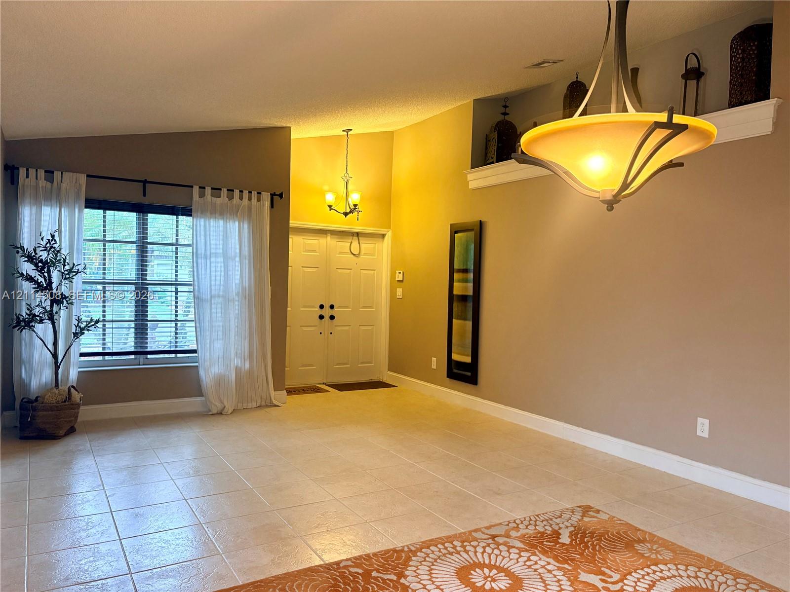 Vaulted ceilings, built-in recessed display shelving, ceramic tile flooring, double-entry front doors, and dual decorative hanging light fixtures Vaulted ceilings, built-in recessed display shelving, ceramic tile flooring, double-entry front doors, and dual decorative hanging light fixtures