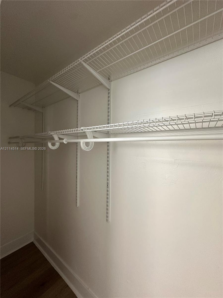 White wire shelving system featuring dual-tier hanging rods and adjustable track-mounted supports
